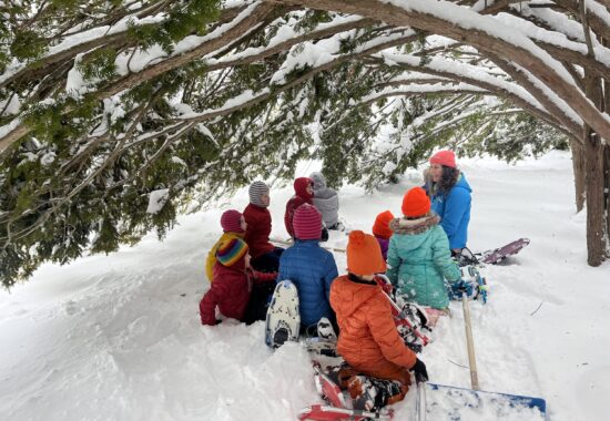 Susie Spikol with homeschoolers under a yew tree in winter